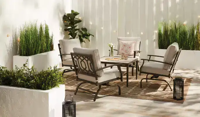 Neutral-toned outdoor lounge set surrounded by tall plants