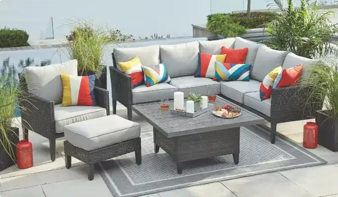 Grey wicker outdoor lounge set with colorful cushions