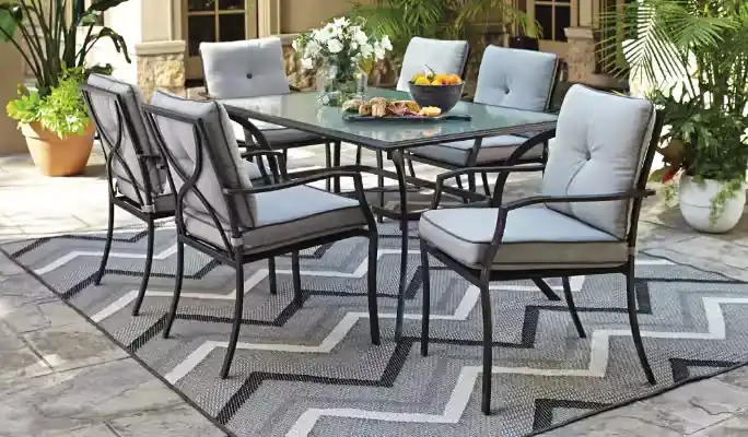 Outdoor dining table with grey chairs on stone patio